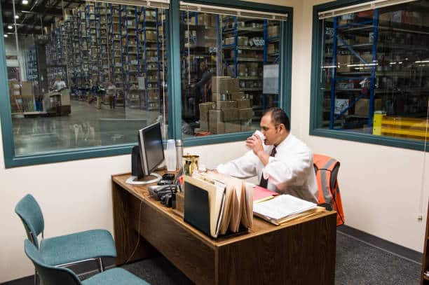 Employé installé à son bureau dans un atelier industriel